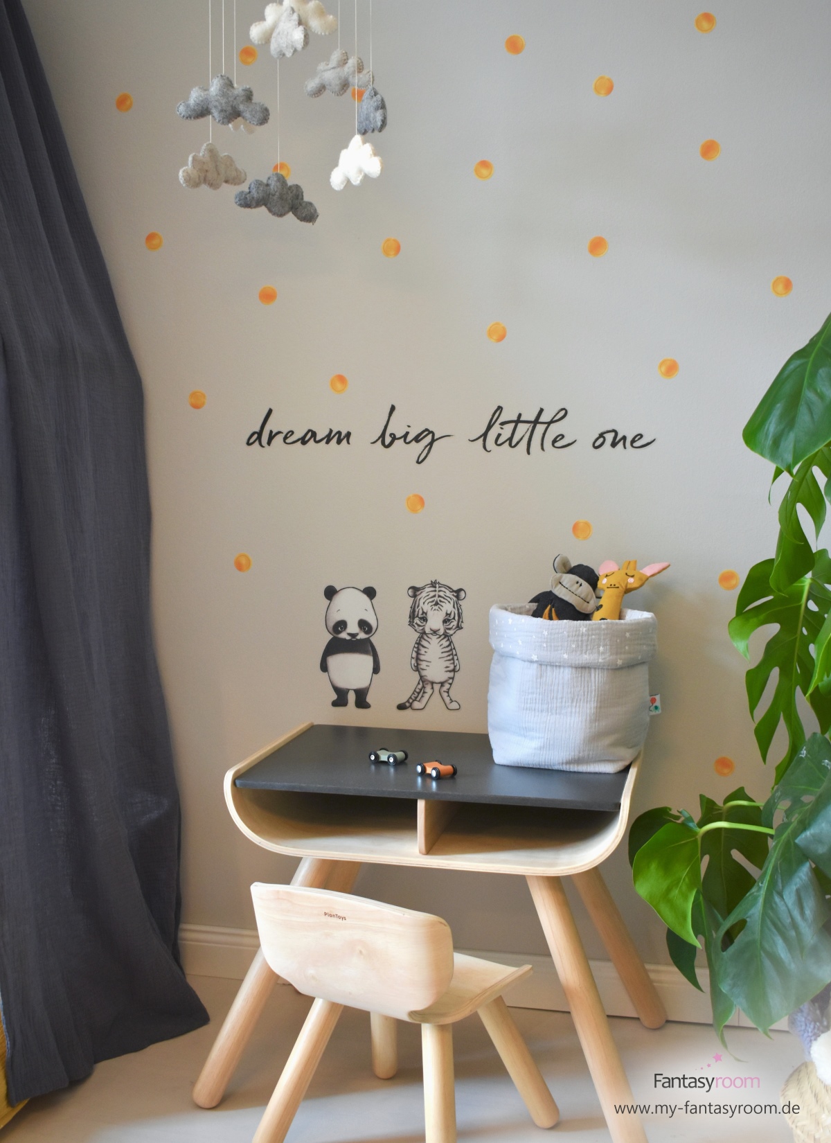 Kinderzimmer mit senfgelben Punktestickern an der grauen Wand und Sitzgruppe von Plantoys